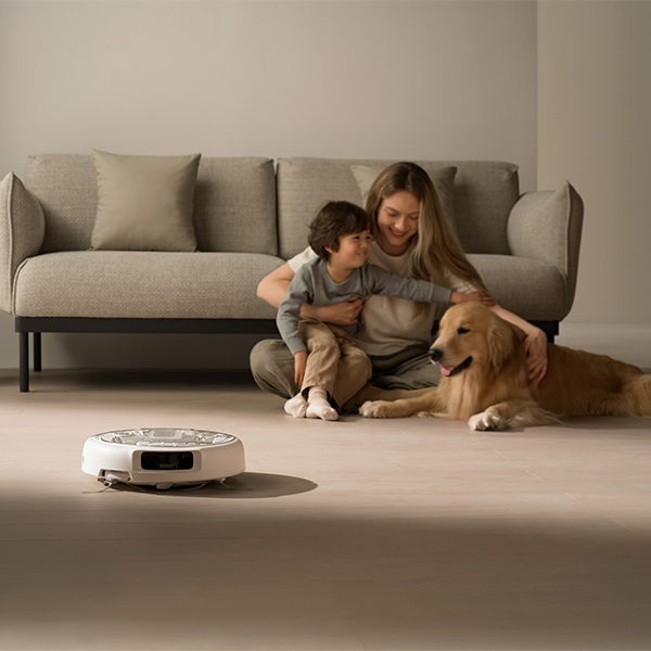 Aspirateur DJI ROMO proche d'une famille avec chien